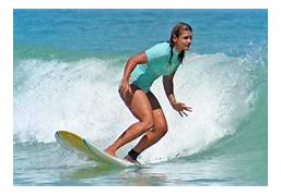 A woman riding the waves on top of a surfboard.