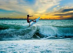 A man riding the waves on top of a surfboard.